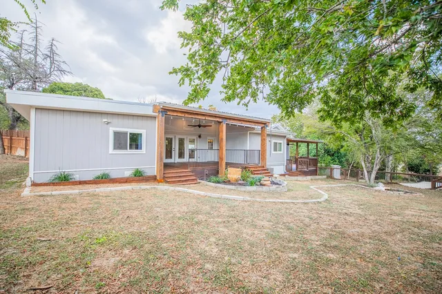 a view of a house with backyard and sitting area