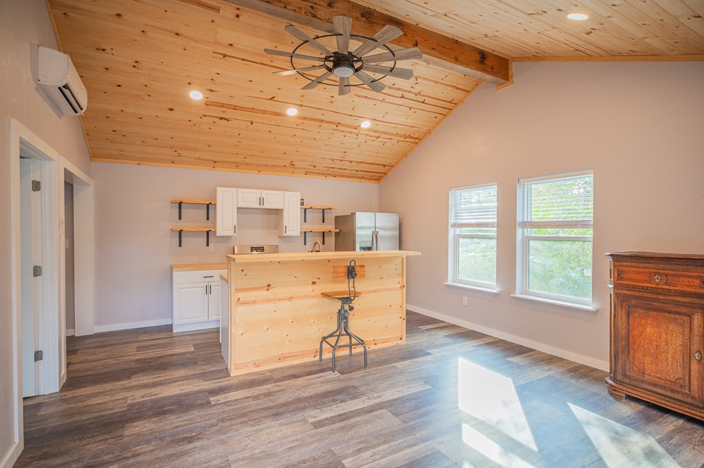 2181 Goat Creek Road Kerrville, TX 78028 - Photo 22 of 25 a room with kitchen island stainless steel appliances wooden floor and chandelier