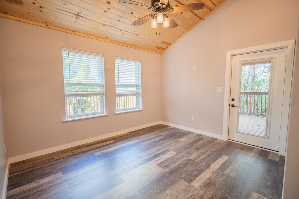 2181 Goat Creek Road Kerrville, TX 78028 - Photo 23 of 25 a view of an empty room with wooden floor and a window