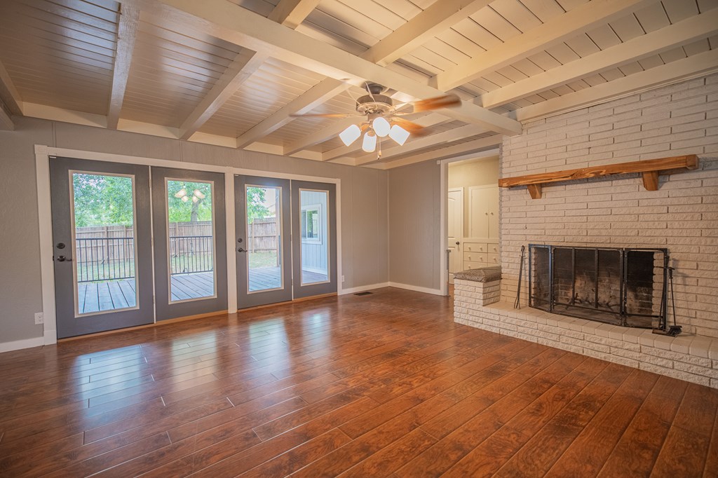 2181 Goat Creek Road Kerrville, TX 78028 - Photo 4 of 25 a view of an empty room with wooden floor fireplace and a window