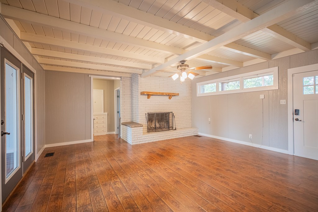 2181 Goat Creek Road Kerrville, TX 78028 - Photo 5 of 25 a view of empty room with wooden floor and fireplace