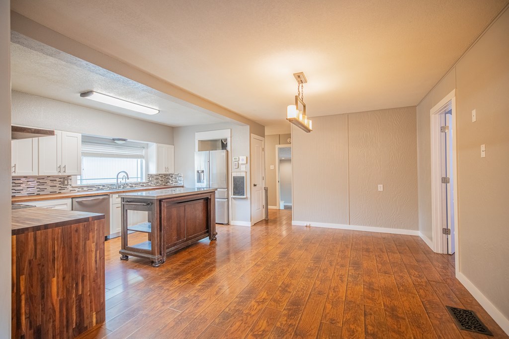 2181 Goat Creek Road Kerrville, TX 78028 - Photo 6 of 25 a view of kitchen with granite countertop a refrigerator a sink dishwasher a dining table and chairs with wooden floor