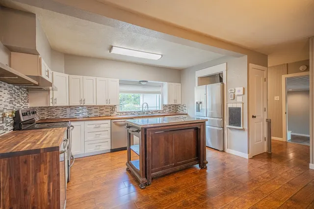 a kitchen with stainless steel appliances granite countertop a stove and a sink