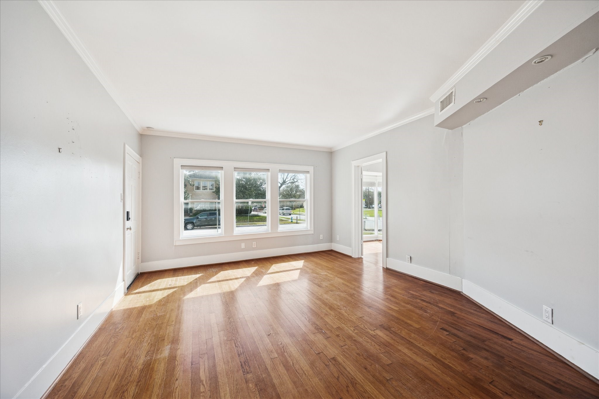 1758 Hawthorne Street Houston, TX 77098 - Photo 4 of 27 an empty room with wooden floor and windows