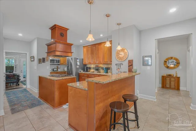 a large kitchen with kitchen island granite countertop a large counter top and stainless steel appliances
