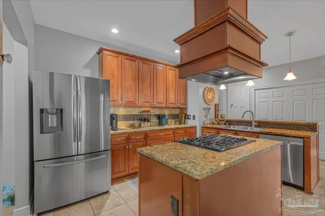 a kitchen with stainless steel appliances granite countertop a refrigerator a stove and a refrigerator