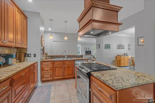 a kitchen with stainless steel appliances granite countertop a stove a sink dishwasher and cabinets