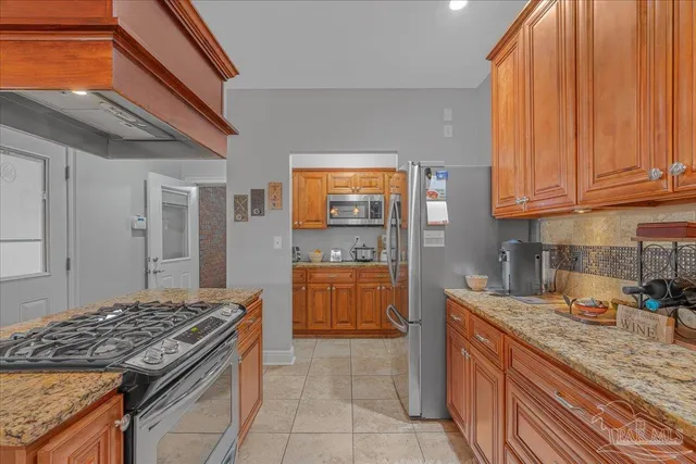 a kitchen with stainless steel appliances granite countertop a stove a sink and a microwave
