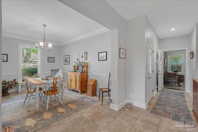 a living room with furniture a dining table and a chandelier