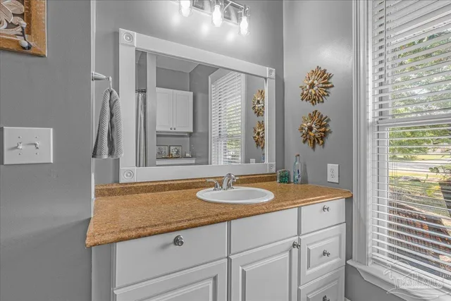 a bathroom with a granite countertop sink and a mirror