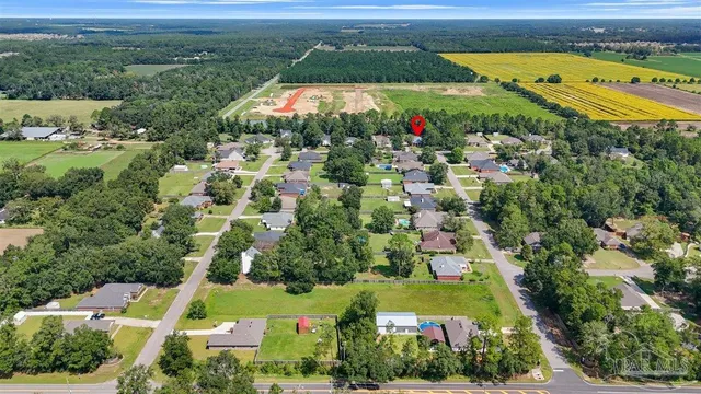 an aerial view of residential houses with outdoor space and trees
