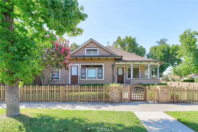 a front view of a house with a garden and trees
