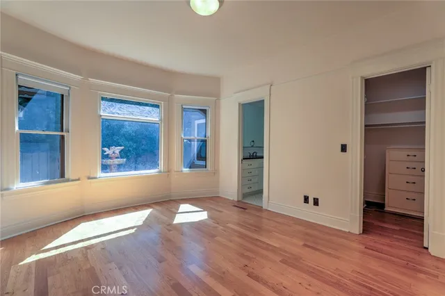 a view of a backyard with table and chairs potted plants and large tree