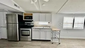 a kitchen with kitchen island a sink cabinets and stainless steel appliances