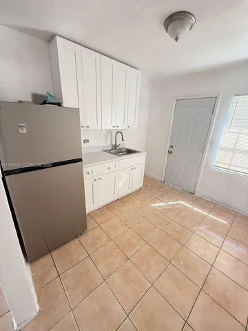 a kitchen with a cabinets and a refrigerator