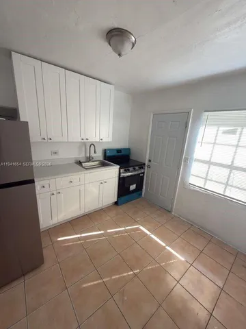 a kitchen with a sink a stove and cabinets