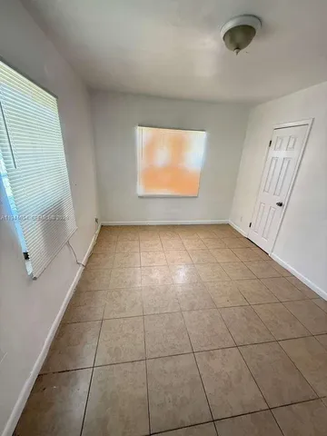 an empty room with windows and entrance