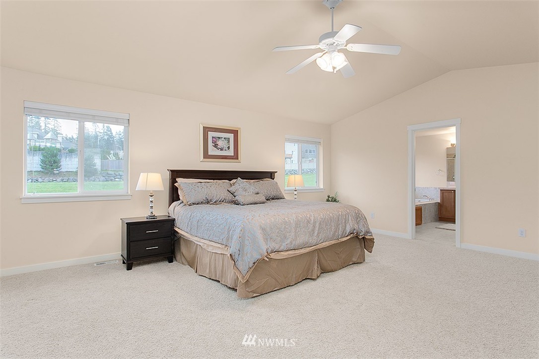 21913 42 Avenue Southeast Bothell, WA 98021 - Photo 12 of 24 a spacious bedroom with a bed and a chandelier