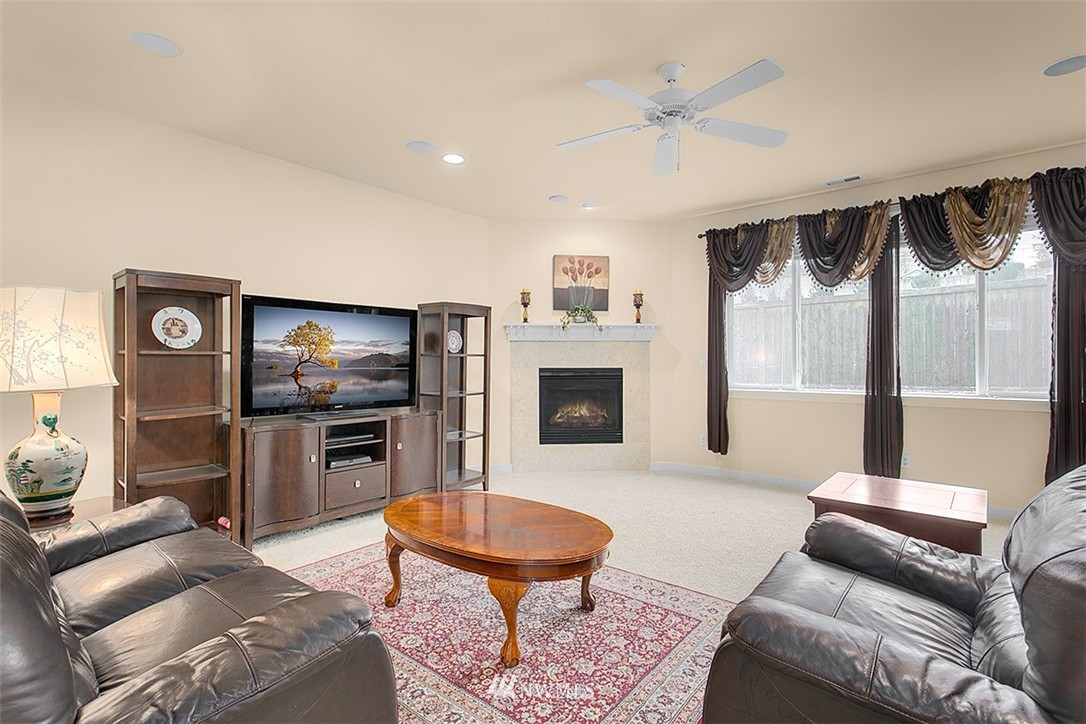 21913 42 Avenue Southeast Bothell, WA 98021 - Photo 8 of 24 a living room with furniture a fireplace and a flat screen tv
