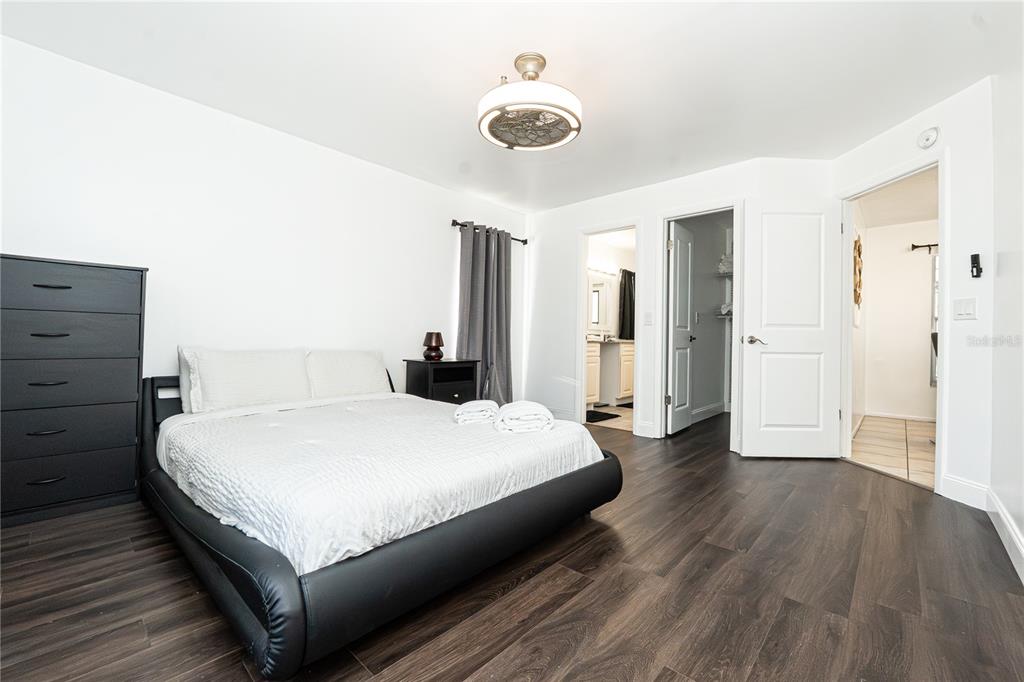 7720 Indian Ridge Trail South Kissimmee, FL 34747 - Photo 11 of 35 a spacious bedroom with a bed and wooden floor