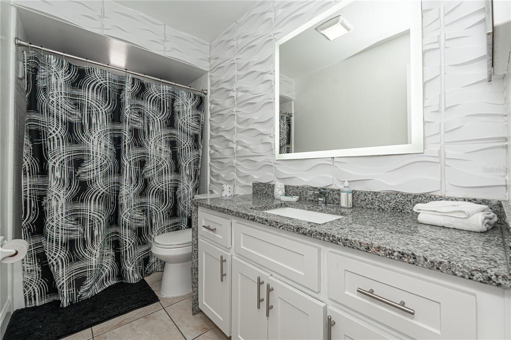7720 Indian Ridge Trail South Kissimmee, FL 34747 - Photo 18 of 35 a bathroom with a granite countertop sink and a mirror