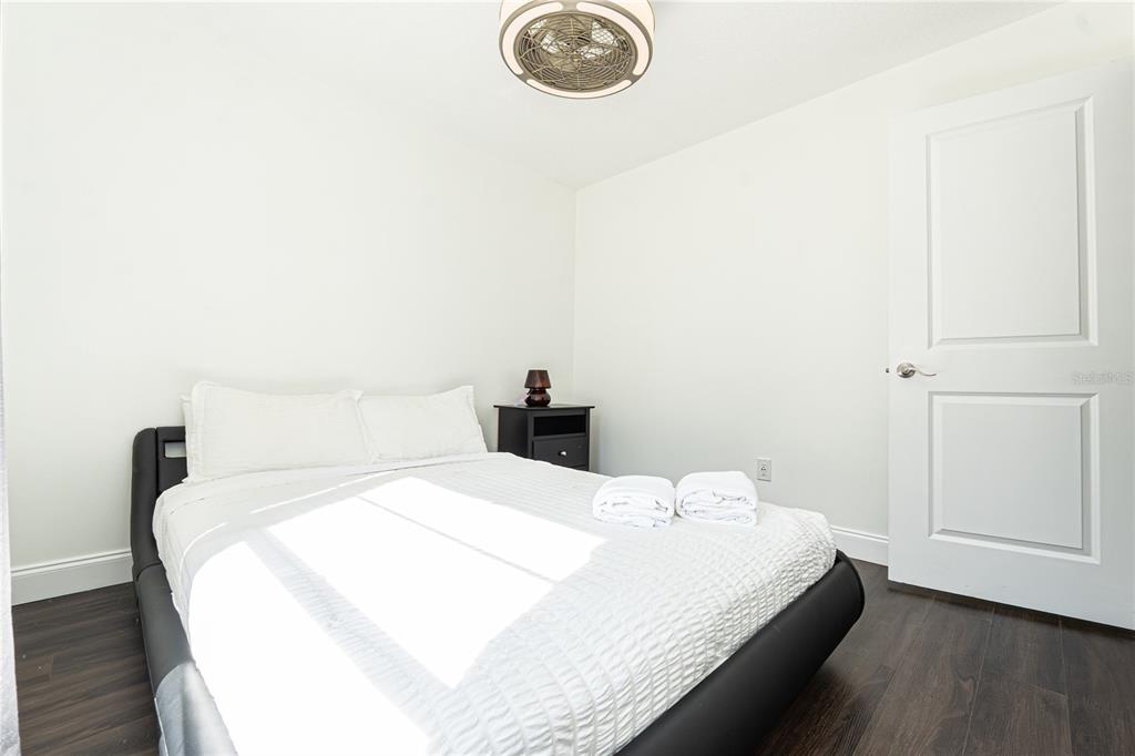 7720 Indian Ridge Trail South Kissimmee, FL 34747 - Photo 19 of 35 a bedroom with a bed and a chandelier