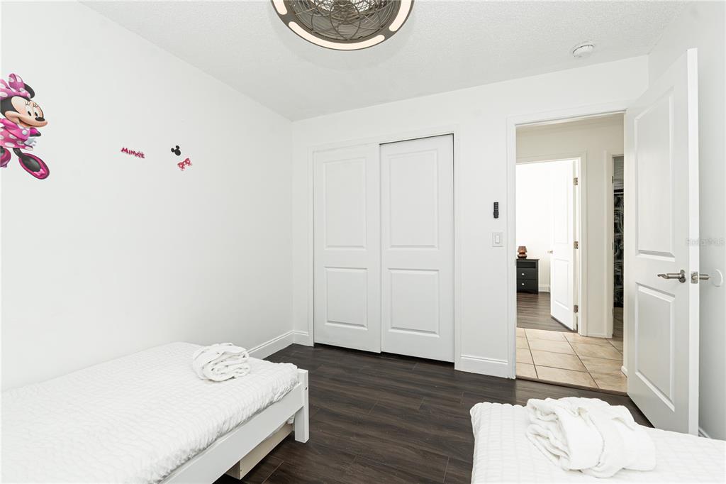 7720 Indian Ridge Trail South Kissimmee, FL 34747 - Photo 22 of 35 a bedroom with a bed and wooden floor