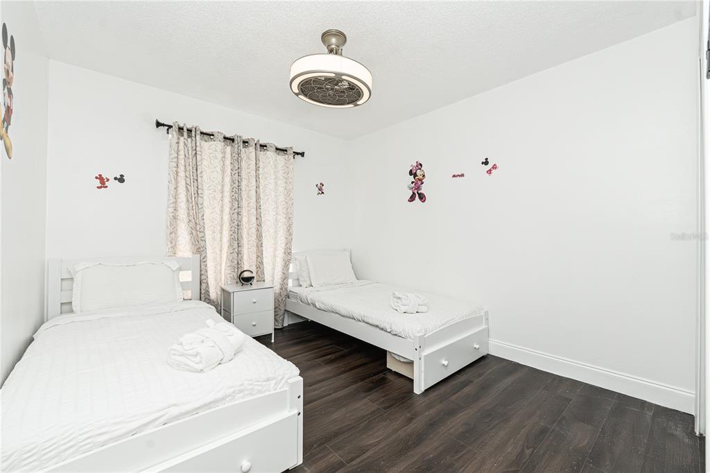 7720 Indian Ridge Trail South Kissimmee, FL 34747 - Photo 24 of 35 a spacious bedroom with a bed and a chandelier