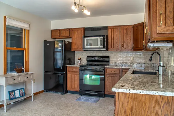 a kitchen with kitchen island granite countertop a stove and a refrigerator