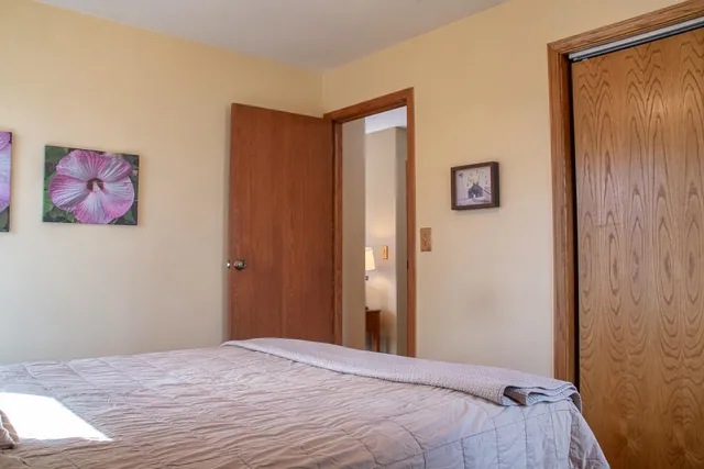 a bedroom with a bed and a painting on the wall