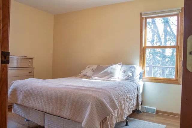 a bedroom with a bed and wooden floor