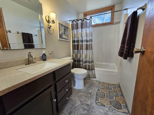 a bathroom with a double vanity sink toilet mirror and shower