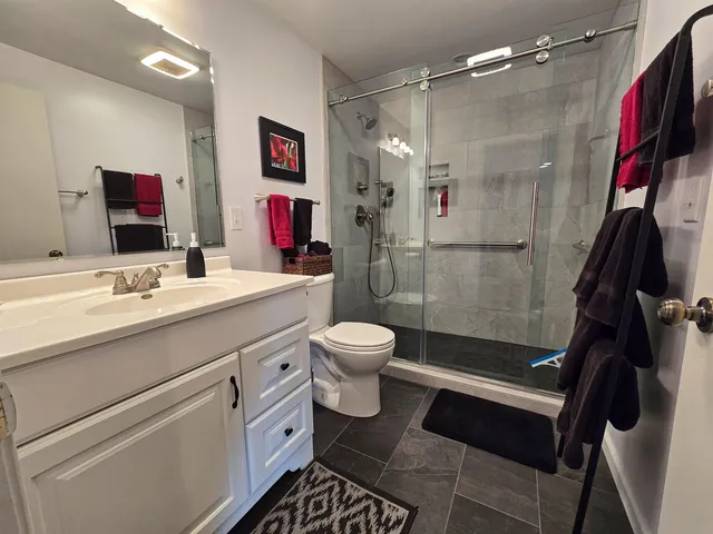 a bathroom with a sink a toilet and shower