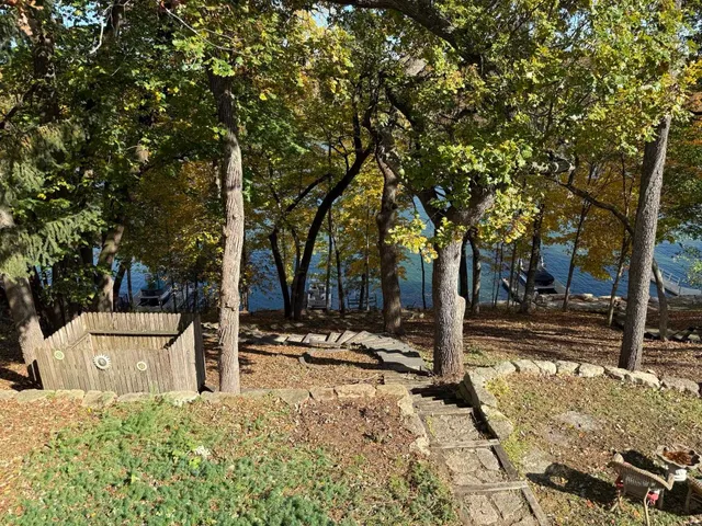 a front view of a house with trees and covered with snow