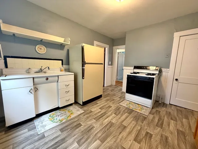 a kitchen with a stove refrigerator and white cabinets