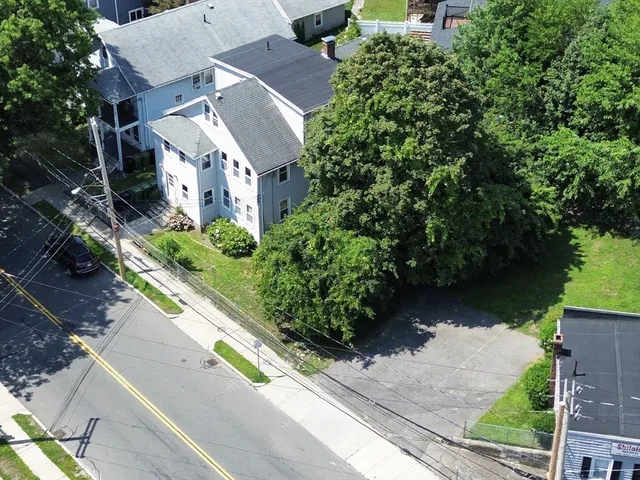an aerial view of a house with garden space and a street view