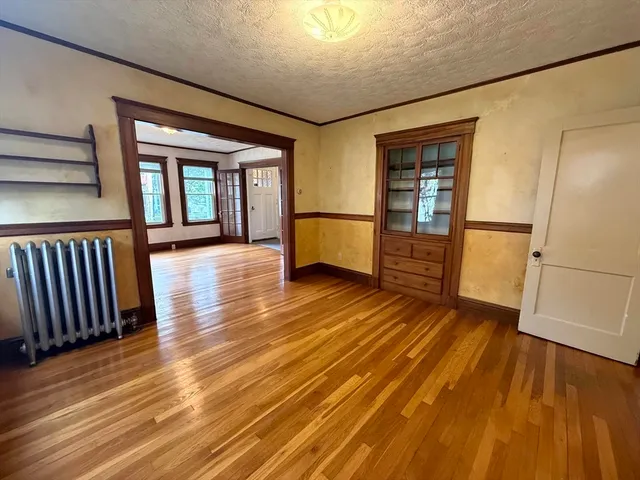 an empty room with wooden floor and entrance