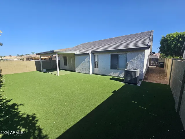 a view of a house with a yard and sitting area