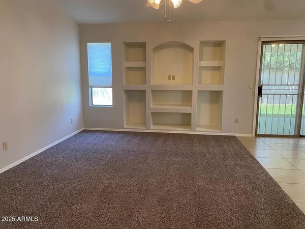 an empty room with windows and cabinet