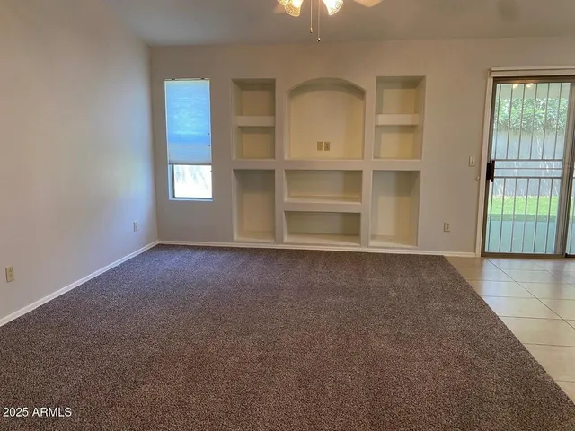 an empty room with windows and cabinet