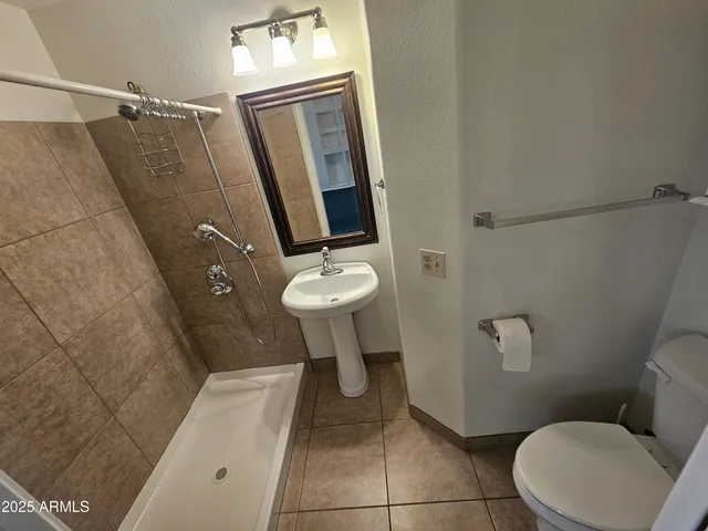 a bathroom with a toilet and a shower
