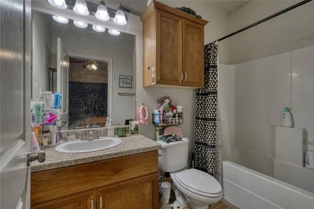 a bathroom with a sink a toilet a mirror and shower