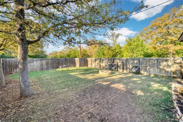 a view of yard with tree and wooden fence