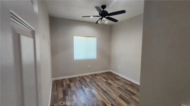 a view of a room with wooden floor and fan