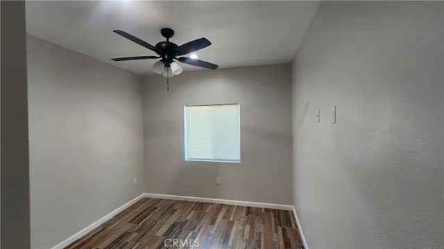 a view of room with hardwood floor and ceiling fan