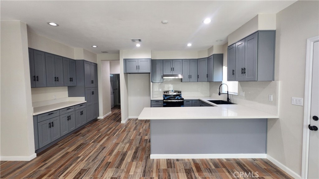 3433 Eucalyptus Avenue Riverside, CA 92507 - Photo 29 of 38 a large kitchen with stainless steel appliances granite countertop a lot of counter space and wooden floors