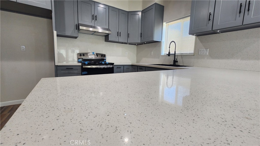 3433 Eucalyptus Avenue Riverside, CA 92507 - Photo 30 of 38 a kitchen with granite countertop a sink a stove and cabinets