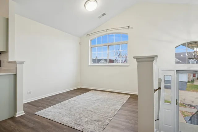 an empty room with wooden floor and a window