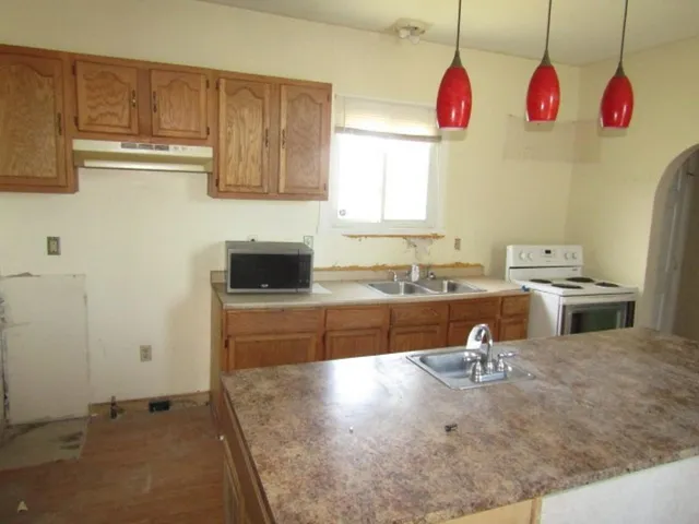 a kitchen with a sink a stove and cabinets