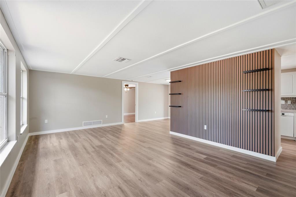 5984 Diana Road Venice, FL 34293 - Photo 6 of 36 a view of an empty room with wooden floor and a window
